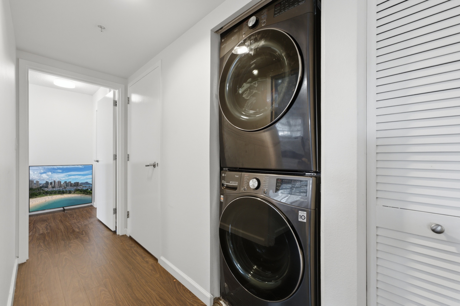 Hallway with stacked LG washer and dryer and city view beyond