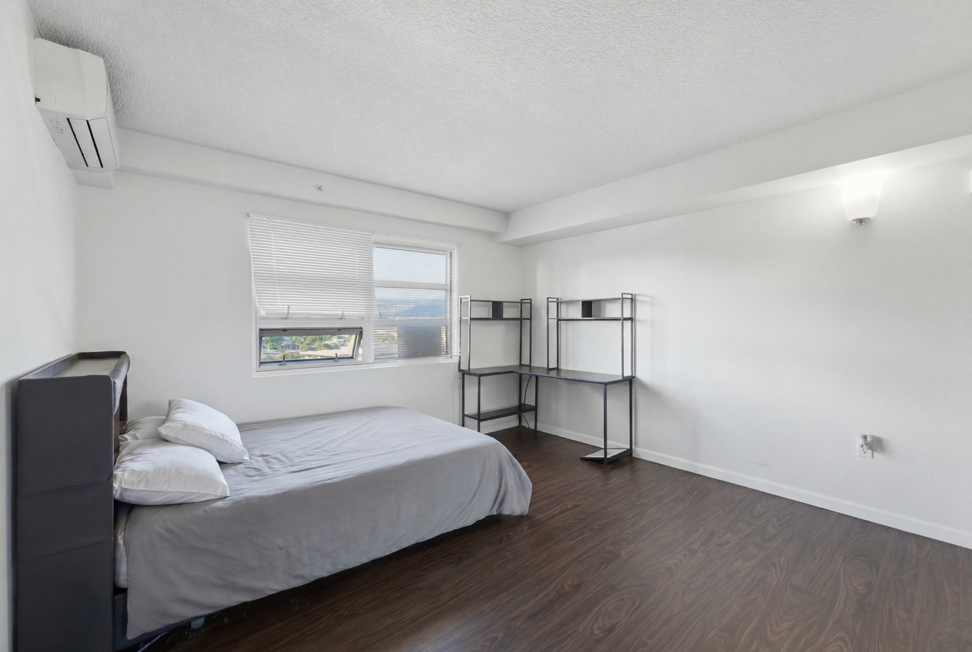 Third bedroom showing desk, shelving, and window with view